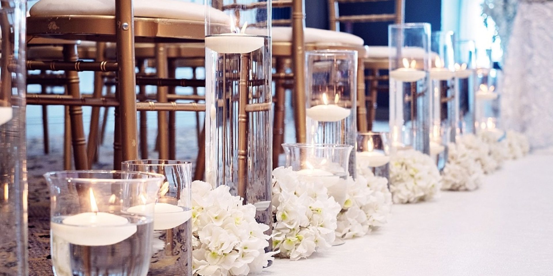 floating candles running down the side of wedding aisle with bunches of decorative flowers