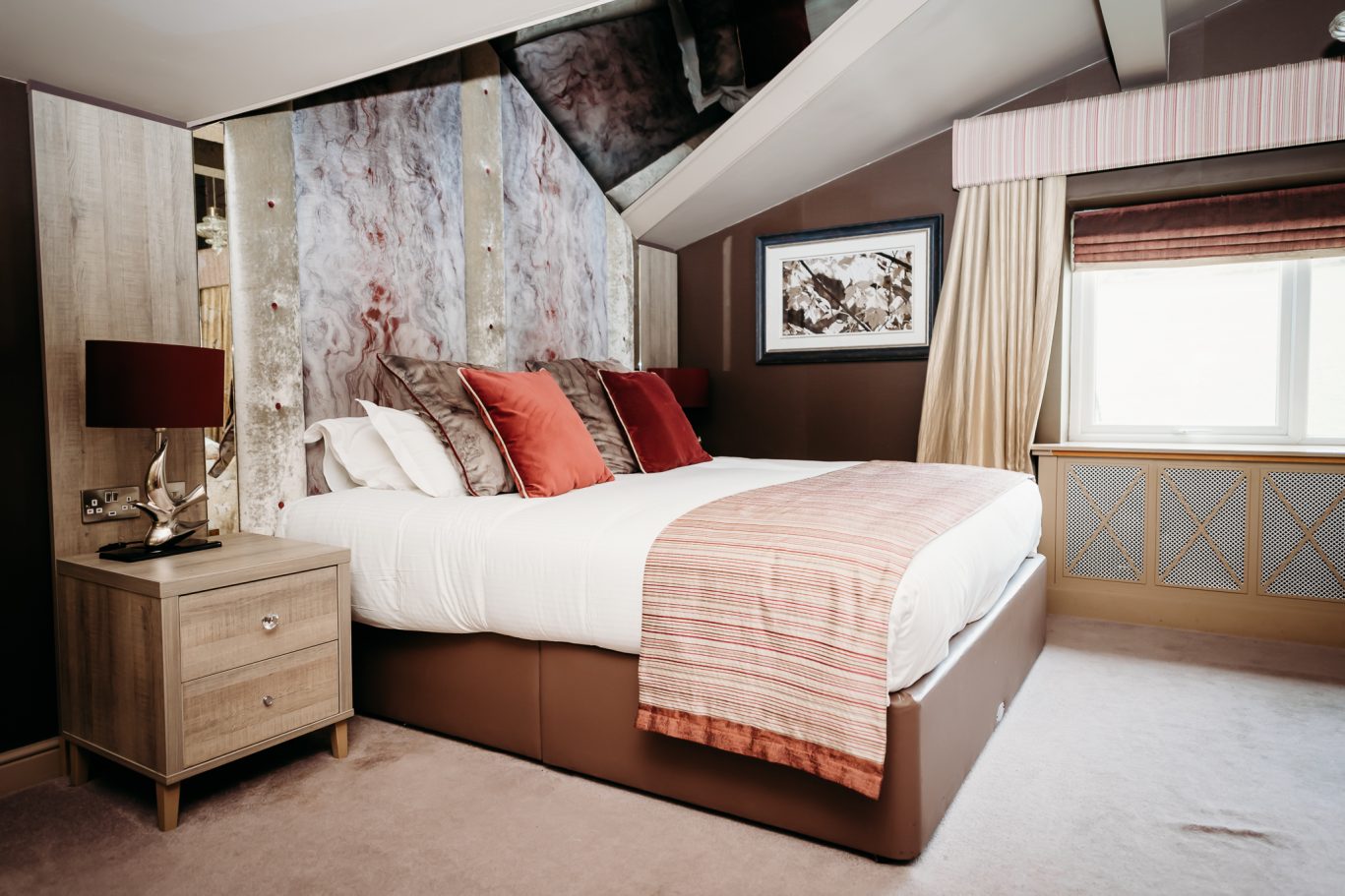 Red Hall Hotel bedroom with red cushions and red runner with burgundy accents