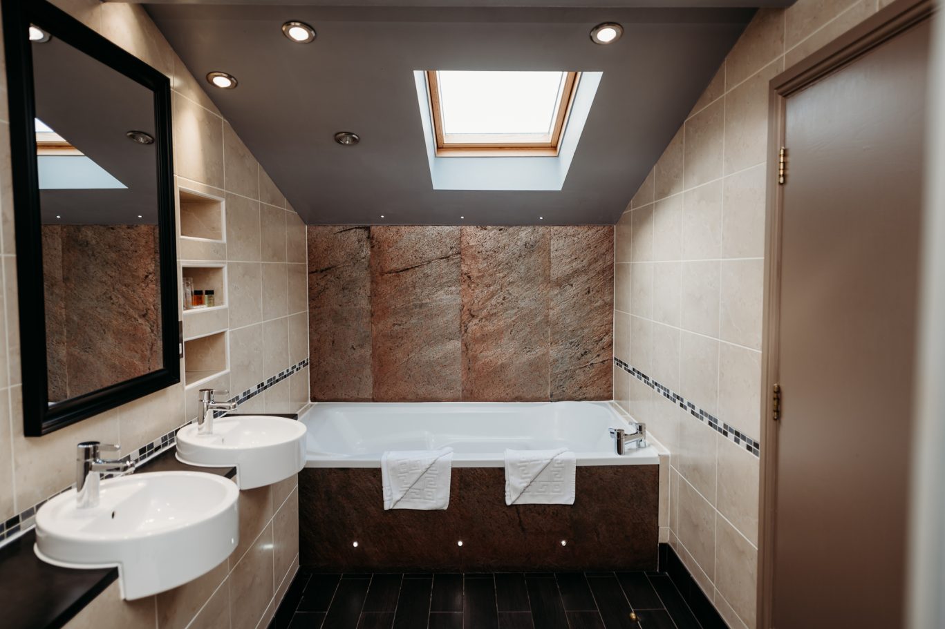 large bathroom with big bath at the end and two sinks