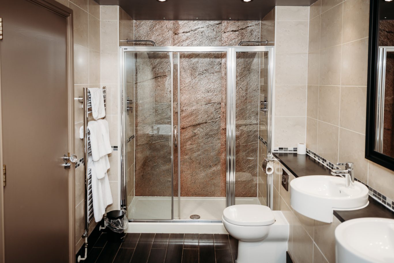 large bathroom with two sinks, and large double shower with two shower heads