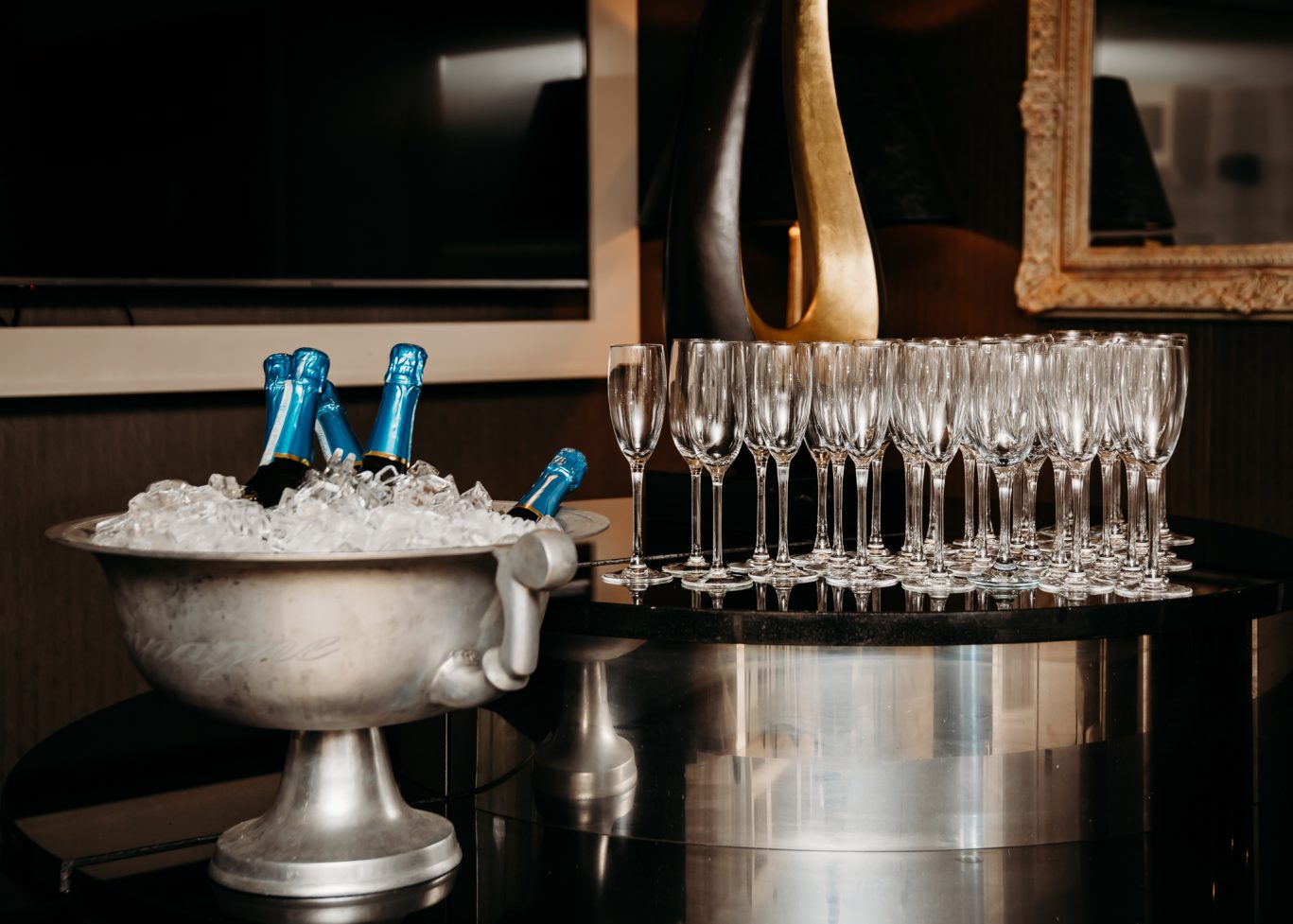 champagne glasses and an ice bucket with five bottles of champagne