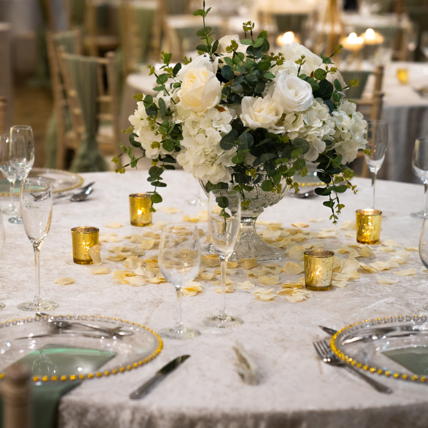 wedding round table with white cream rose bouquet and petals around the table