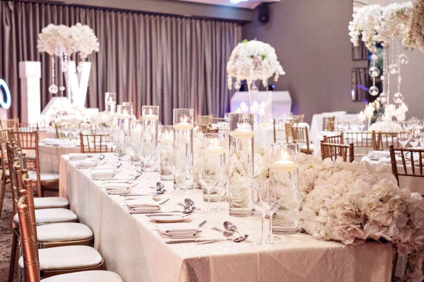 wedding top table with decorative white flowers and floating candles