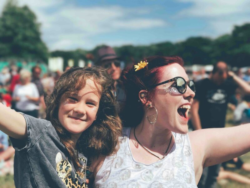 A mother and daughter smiling and enjoying a festival in the sun. One of many things to do in Bury